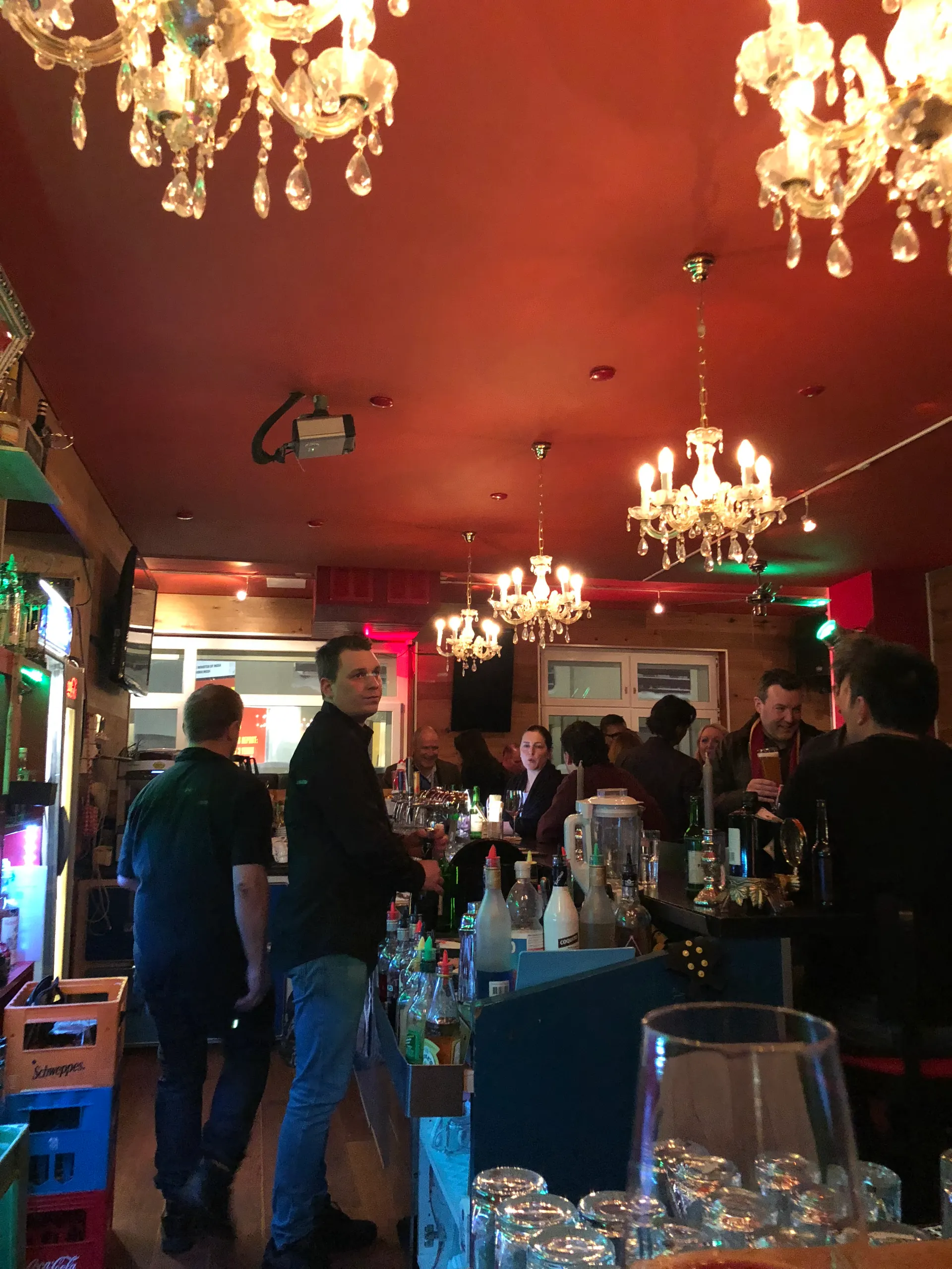 A crowded bar during Davos Annual Meeting week, chandeliers overhead