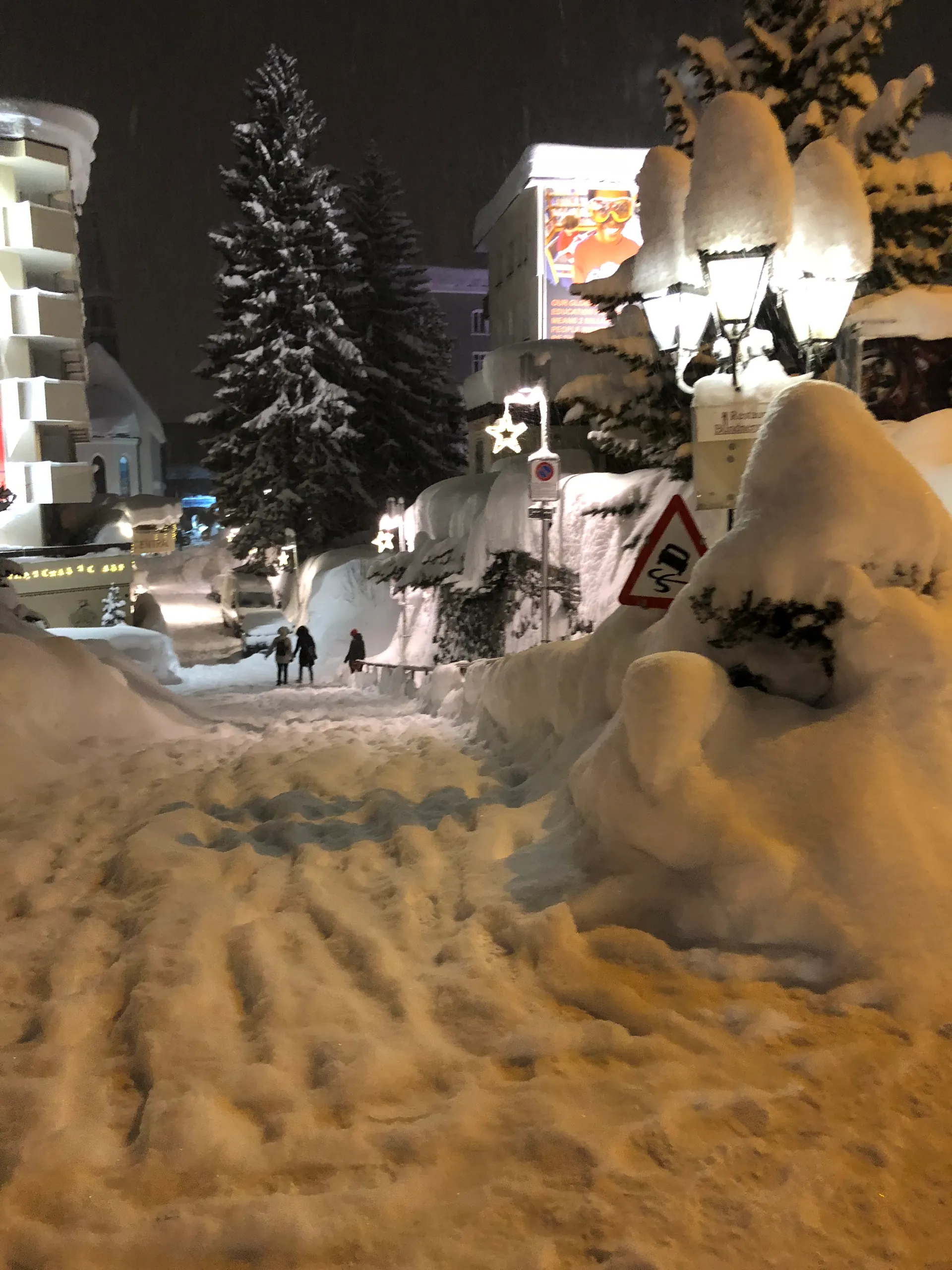 People walking single file on a snow-packed Davos pavement
