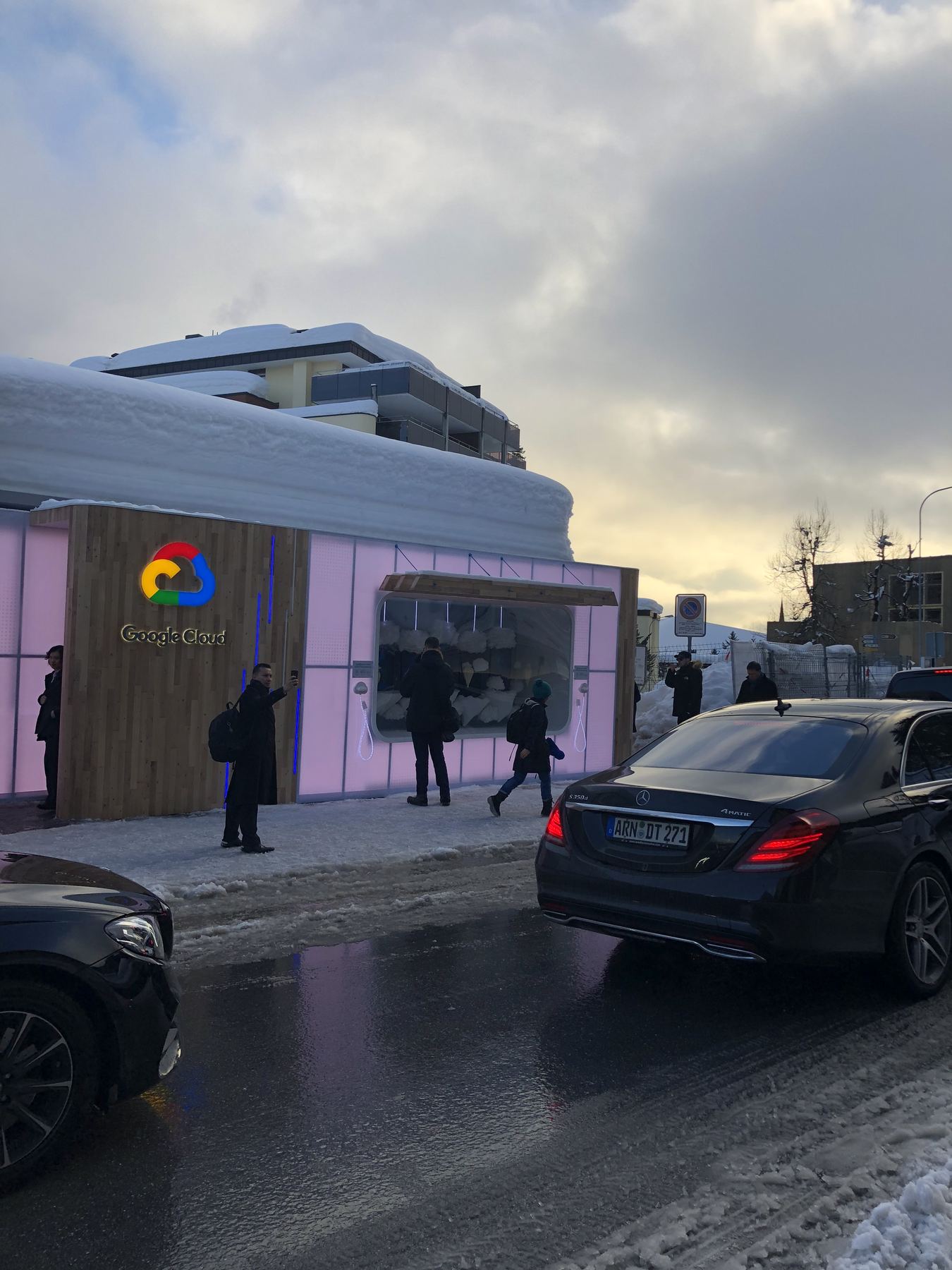 A temporary Google Cloud house on the Davos Promenade, branded and lit for the week