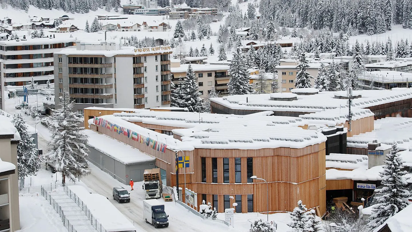 A WEF accreditation lanyard against a Davos winter backdrop